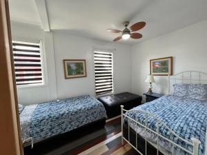 a bedroom with two beds and a ceiling fan at Le 2316 in Saint-Hyacinthe