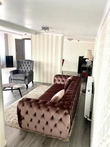 a living room with a brown leather couch in a room at Hotel City Break in Galaţi