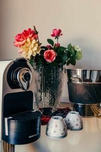 un appareil photo et un vase avec des fleurs sur une table dans l'établissement Bed and Breakfast Villa Romano, à Anzio
