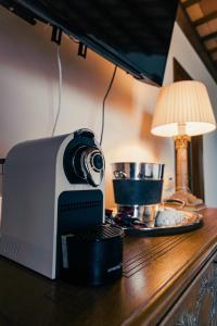 eine Kaffeemaschine auf einem Tisch neben einer Lampe in der Unterkunft Bed and Breakfast Villa Romano in Anzio