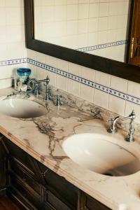 ein Badezimmer mit zwei Waschbecken und einem großen Spiegel in der Unterkunft Bed and Breakfast Villa Romano in Anzio
