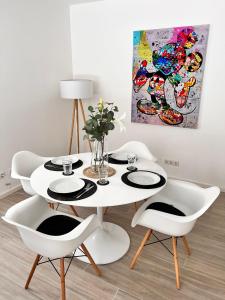 uma sala de jantar com uma mesa branca e cadeiras em Veens Crew Home 4 Pax em Dreieich