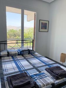 een slaapkamer met een bed en uitzicht op de bergen bij Wait 'n Sea Apartment by A&D Properties in Porto Rafti