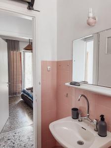 een badkamer met een wastafel en een spiegel bij Wait 'n Sea Apartment by A&D Properties in Porto Rafti