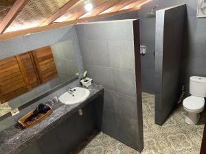 y baño con lavabo y aseo. en Mangrove Beach Hut en Nusa Lembongan