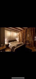 sypialnia z dużym łóżkiem i ceglaną ścianą w obiekcie Le Petit Secret, Korce, Albania w mieście Korcza