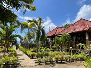 a house with a garden and palm trees at Mangrove Beach Hut in Nusa Lembongan