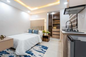 a bedroom with a bed and a kitchen at Sapphire Heights Apartment Single Rooms in Lagos