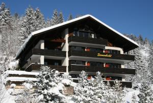 a building in the snow with snow covered trees at Landhaus Sonnenbichl Mittenwald in Mittenwald