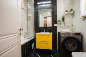 een badkamer met een wasmachine en een gele kast bij Romantic getaway at West Residence in Oradea