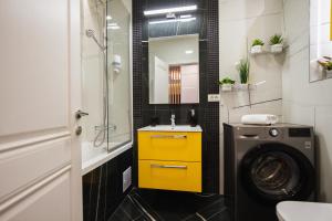 a bathroom with a washing machine and a yellow cabinet at Romantic getaway at West Residence in Oradea