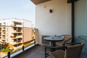 een balkon met een tafel en stoelen en een gebouw bij Romantic getaway at West Residence in Oradea