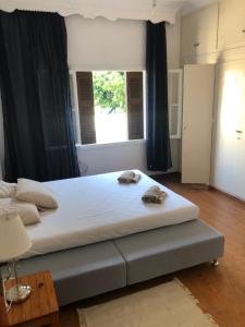 ein großes Bett in einem Zimmer mit einem großen Fenster in der Unterkunft Al Mare Skyros, Fully-equipped house in Skyros