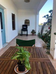 einen Holztisch mit einer Pflanze auf einer Terrasse in der Unterkunft Al Mare Skyros, Fully-equipped house in Skyros