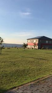 a large grass field with a building in the background at 36 Emanzini Villa in Denysville