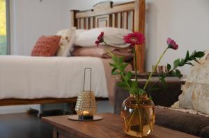 een woonkamer met een vaas met bloemen op een tafel bij Wagtail Nest Country Retreat - Longford Vic 3851 in Sale