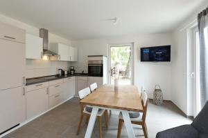 een keuken met een houten tafel en witte kasten bij Apartment unter den Kiefern 109 in Röbel