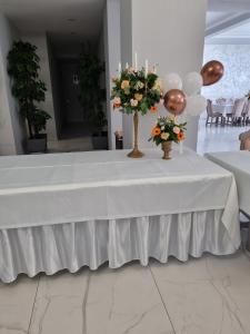 a table with a white table cloth and flowers on it at Hotel Transit in Oradea