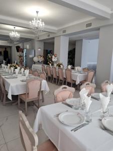 a dining room with white tables and chairs at Hotel Transit in Oradea