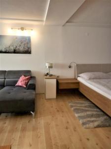 ein Wohnzimmer mit einem Bett und einem Sofa in der Unterkunft Ferienwohnungen Anna Balazs in Illmitz