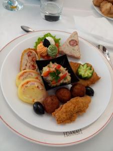a plate of food with different foods on a table at Hotel Transit in Oradea