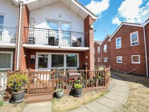 a house with a wooden fence and potted plants at 30 The Waterside Holiday Park in Lowestoft