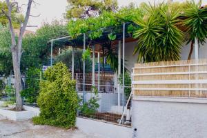 una casa con una valla y algunas plantas en Ευχάριστη Βίλα, 90 μέτρα από τη θάλασσα, en Agioi Theodoroi