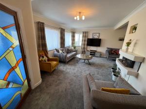 a living room with a couch and a tv at The Emberton in Bridlington