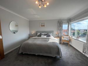 a bedroom with a bed and a large window at The Emberton in Bridlington
