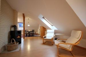 ein Wohnzimmer mit 2 Stühlen und einem Holzofen in der Unterkunft Studio Sonnenstrahl by Rujana in Binz