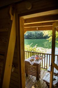 a view from the inside of a cabin with a table on a balcony at Riverland in Gornji Zvečaj