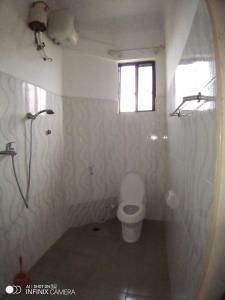 a bathroom with a toilet and a window at Masami lodge boma ng'ombe in Tuvaila