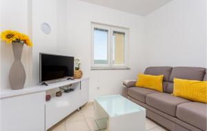 uma sala de estar com um sofá e uma televisão em 3 Bedroom Cozy Apartment In Dobrinj em Dobrinj