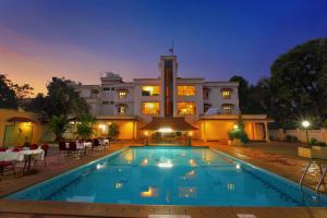a hotel with a swimming pool in front of a building at Quality Airport Hotels in Nedumbassery