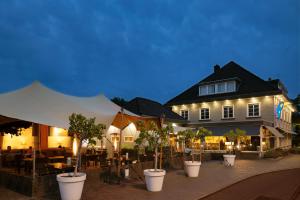 a building with a bunch of potted trees in front of it at Van der Valk Hotel De Molenhoek-Nijmegen in Molenhoek