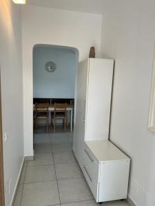 クルジュ・ナポカにあるCluj Napoca Apartament Lux Cuza Vodaの白い冷蔵庫付きのキッチン(テーブル付)