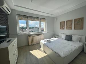 1 dormitorio blanco con 1 cama y 2 ventanas en Cluj Napoca Apartament Lux Cuza Voda, en Cluj-Napoca
