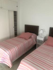 two beds sitting next to each other in a bedroom at Depto More III in Puerto Madryn