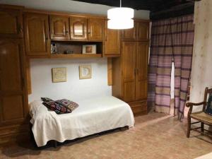 een slaapkamer met een bed met houten kasten en een stoel bij Casa do Hiebra Alojamiento Rural Ribeira Sacra 