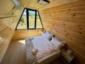 ein kleines Zimmer mit einem Bett in einer Holzhütte in der Unterkunft Liniștea Muntilor Cartioasra in Cîrţişoara