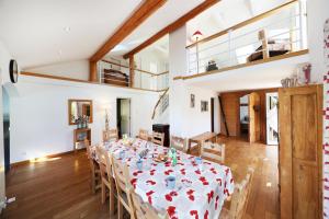 ein Esszimmer mit einem langen Tisch und Stühlen in der Unterkunft LE CHALET BLANC - JACUZZI / PISCINE / SAUNA in Gérardmer