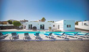 a group of chairs sitting next to a swimming pool at Casa Conil with a private 25 meter heated pool in Conil
