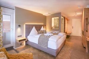 ein Schlafzimmer mit einem großen Bett in einem Zimmer in der Unterkunft Hotel Restaurant Der Engel, Sasbachwalden in Sasbachwalden