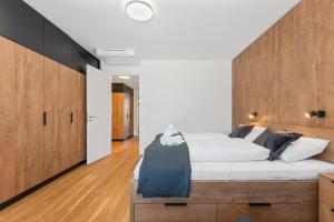 - une chambre avec un grand lit et une tête de lit en bois dans l'établissement Apartmán Molo Lipno, à Lipno nad Vltavou