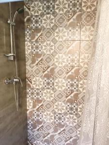 ein Bad mit einer Dusche und einer Fliesenwand in der Unterkunft MoCo, modern comfort in historic city of Senglea in Senglea