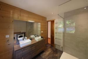 ein Badezimmer mit zwei Waschbecken und einem großen Spiegel in der Unterkunft LE CHALET BLANC - JACUZZI / PISCINE / SAUNA in Gérardmer