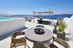 a patio with a table and chairs and a pool at U & ME SUITES in Fira