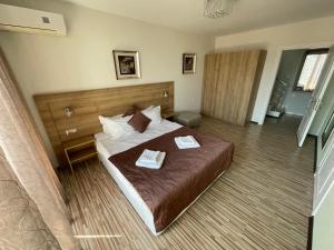 a bedroom with a bed with two towels on it at Private apartments Stamopolu lux in Primorsko