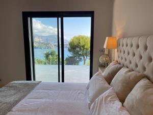 1 dormitorio con 1 cama y puerta de cristal grande en Villa LA ALEGRIA en Niza
