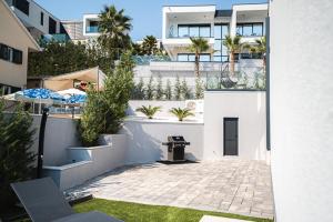 a white building with a patio with an umbrella at Villas-Kroatien in Trogir